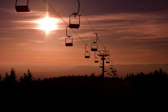 Ski chair lift in the mountains at red sunset