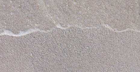 Close-up of white sand, washed by soft sea waves
