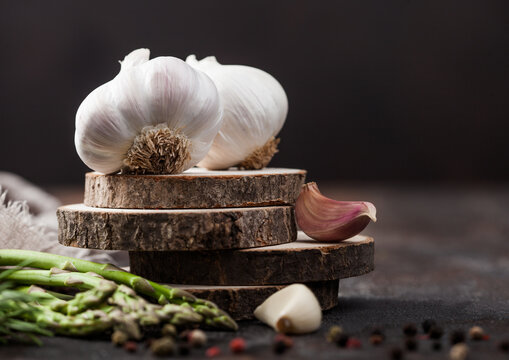 Fresh raw organic garlic with rosemary and asparagus on wooden board.