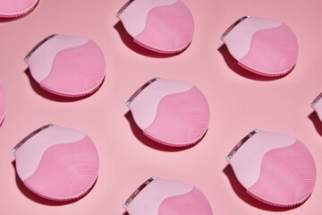 Silicone electric facial cleanser brush for skin care on pink background