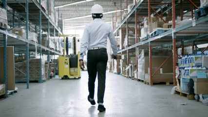 A warehouse manager checks inventory and logistics for an eCommerce facility. Back to work and business is booming. Shot in 4k.