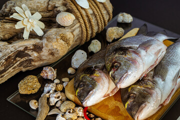 pesce sul tagliere con conchiglie e sfondo in legno