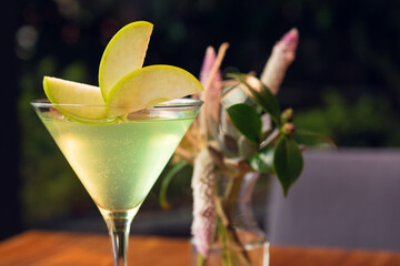 Apple martini on wooden table, sunny weather. Apple martini in sunny summer day.