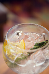 Gin and tonic with rosemary on wooden table, sunny weather. Gin tonic in sunny summer day