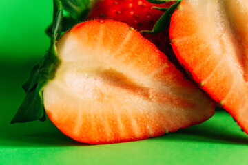 Details Fresh strawberries cut on a green background. Healthy food concept.