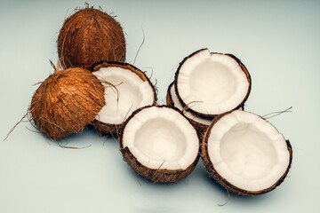 Parts of coconut on a colored background. Close up. Fresh ripe coconut broken into pieces.