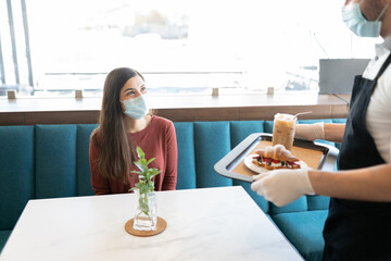 Waiter Serving Order To Customer In Cafe
