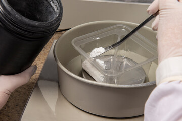 hands with protective gloves of a pharmacy professional handling medicine