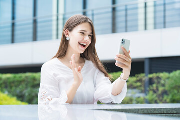 Fototapeta premium スマートフォンを使ってビデオ通話する女性