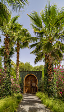 Palm trees alley and entrance door to the unique , beautiful and imaginative public Anima Garden in Marrakesh,Morocco.