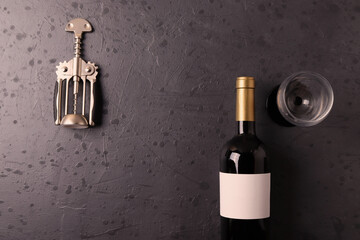 a bottle of red wine on the stone dark grey concrete grunge surface. minimalism style. top view. ...