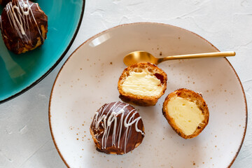 Mini puff cakes with vanilla pudding topped with chocolate