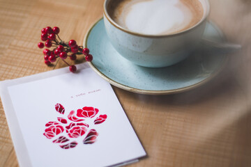 cup of coffee in a cozy cafe with a postcard and a decoration, suitable for personal blogs and instagram pages, also for articles, mirrors cozy atmosphere 