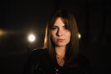 Girl in a leather jacket on an old abandoned construction site