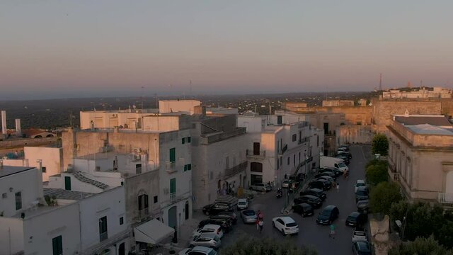 Beautiful Drone shot at Ostuni, the white city in Apulia South Italy at sunset with birds flying in front of the camera