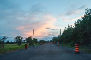 traffic cones lining a country road at dusk