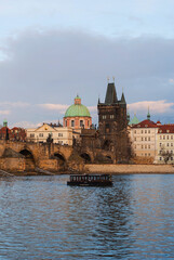 Fototapeta na wymiar Panorama of the city of Prague, Czech Republic on a sunny day. View of Charles Bridge and the bank of the Vltava River. The ship is sailing along the river.