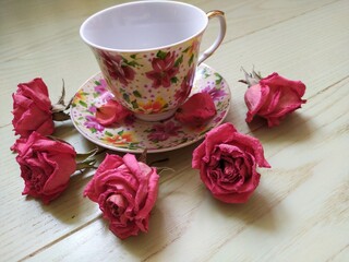 beautiful cup and saucer and dry pink roses