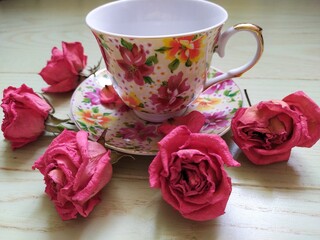 beautiful cup and saucer and dry pink roses