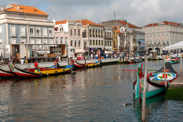 Fototapeta premium river lined with colourful boat and European building with orange roofs in Portugal