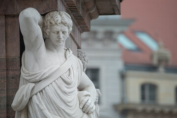 Statue of beautiful Roman noble man at the obelisk in the Old Market square (Alter Markt) in...