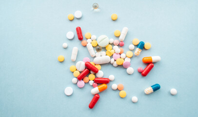 Macro shot of multi-colored pills and capsules heap on a blue background