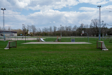 Field hockey nets in large green treelined field with cloud sky