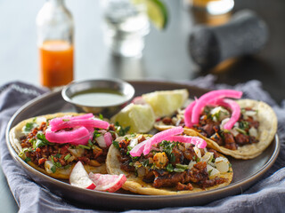 mexican carne asada tacos with pink pickled onions on plate