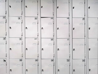 Iron lockers in gray with numbers and locks, in several rows.