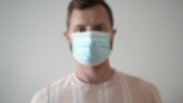 blurred man in mask shows two fingers victory over pandemic or second wave of pandemic part ll