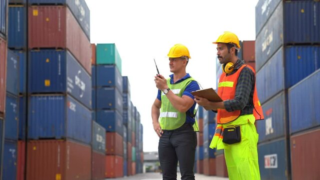 Engineer with foreman control loading Container from Cargo freight ship for import and export , support logistics transportation concept.