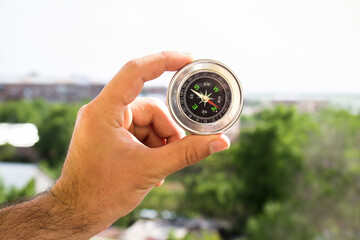 Naklejka premium Holds compass against the background of nature