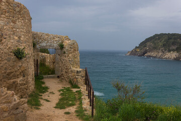 Fototapeta na wymiar Stone building with gate with grating on the sea