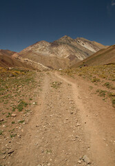 Outdoors activity. Hiking. Dirt path across the arid mountains. 