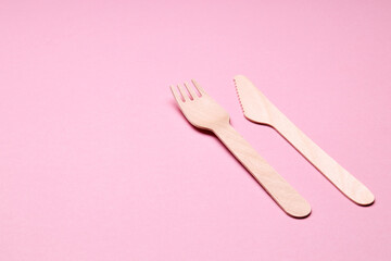 eco-friendly disposable utensills concept. bamboo or wooden cutlery over color background.