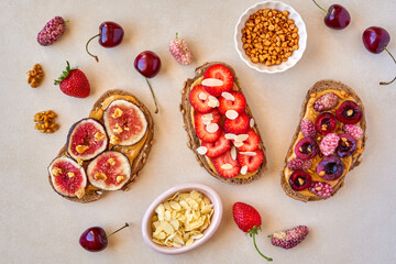 Fototapeta na wymiar Healthy breakfast toasts with peanut butter, strawberry, mulberry , cherry and fig. Top view