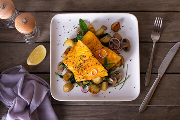 Smoked cod fish fillets with potatoes, mushrooms and spinach. View from above, top studio shot