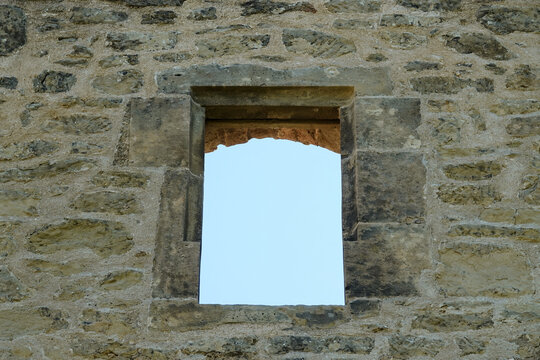 Brown window in a brick castle, blue sky. Germany.