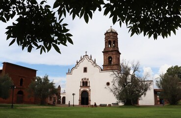 Convento de Santa Ana en Tzintzuntzan México visto detrás de un árbol