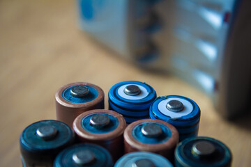 View of rechargeable batteries with recharging unit in background. AA batteries worn out.
