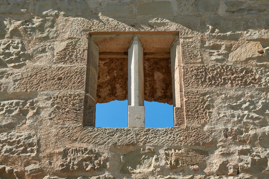Brown window in a brick castle, blue sky. Germany.