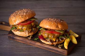Beef burgers and french fries on wooden table. Horizontal image