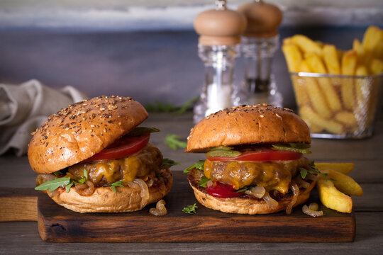 Beef burgers and french fries on wooden table. Horizontal image