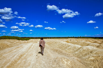 Obraz premium Elegant woman on the background of the Martian landscape. Bornitsky quarry. The village of New Khinkolovo, Gatchinsky district, Leningrad region. Russia