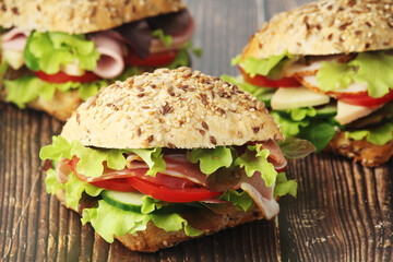 Three sandwiches with whole grain bread, ham and vegetables