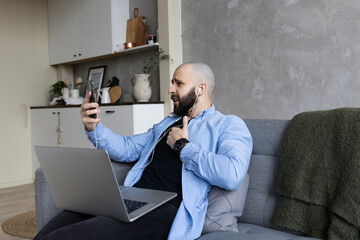 A guy with a beard is talking on a video link at home. The concept of learning and working at home