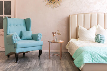 Real photo of a feminine bedroom interior with a comfy armchair, bed