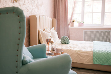 Real photo of a feminine bedroom interior with a comfy armchair, bed