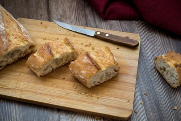 High angle shot of a freshly-baked breast on a wooden cutting board with a knife
