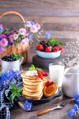 Healthy summer breakfast, homemade pancakes with fresh berry and sour cream on a wooden table